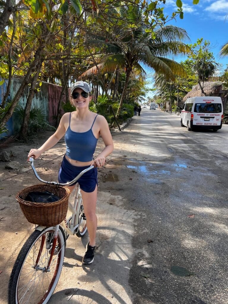 Woman cycling in the beach zone, Tulum 
